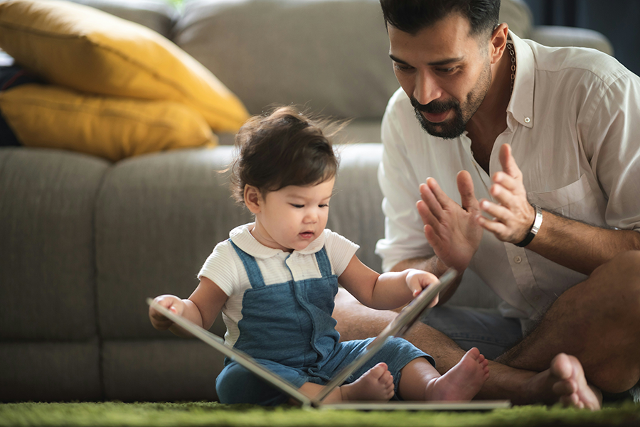 Father and toddler daughter reading a book together