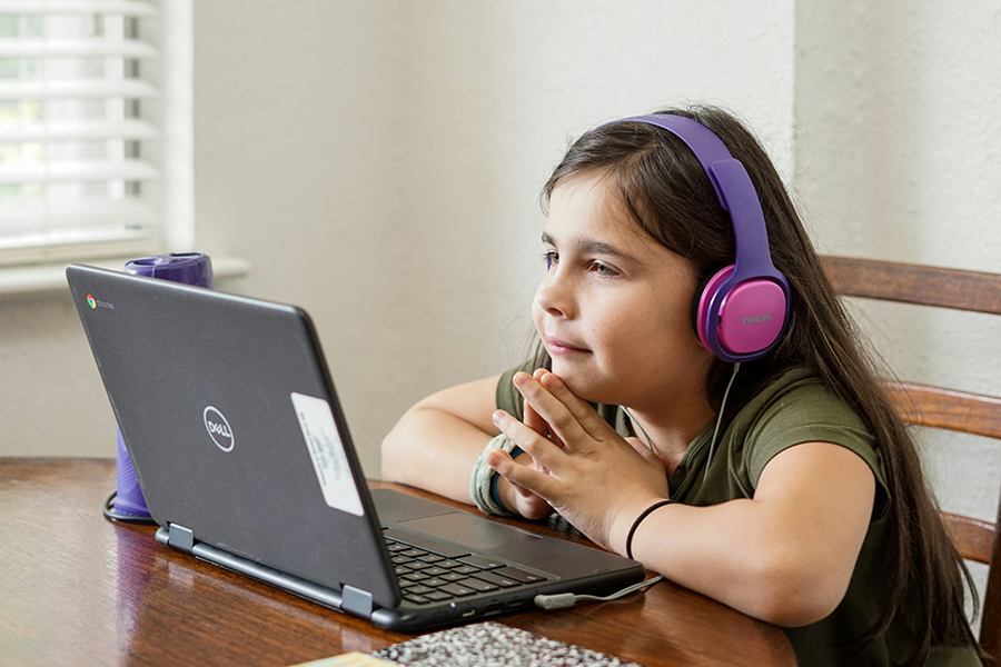 Girl on laptop with headphones on