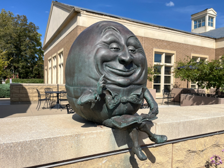 Sculpture of Egg Head sitting on a wall outside of the Batavia Public Library