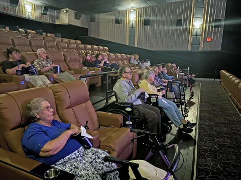 Adults watching a movie in a theatre